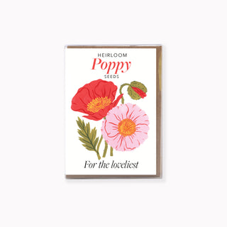 A box of Heirloom Poppy Seed-style greeting cards  featuring an illustration of a red poppy, a light pink poppy, and a green seed pod on a white background, with a kraft envelope visible behind it.