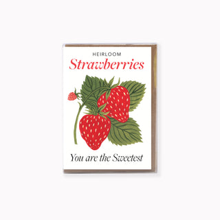 A rectangular greeting card with a white front, featuring an illustration of red strawberries and green leaves, with the text 'HEIRLOOM Strawberries' and 'You are the Sweetest'. The card is shown standing upright against a plain white background.