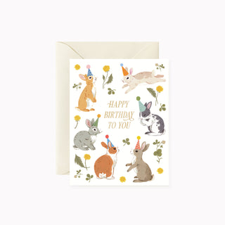 Bunnies Birthday Party greeting card by Oana Befort for Botanica Paper Co. featuring charming illustrated bunnies with gold foil accents on warm white matte cardstock, A2 size with blank interior