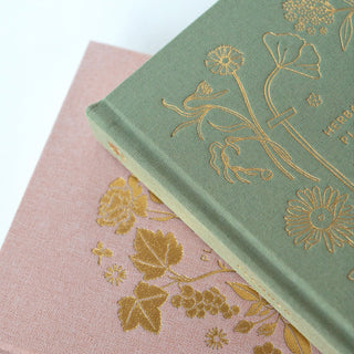 Detail shot of Herbarium planner by Oana Befort highlighting the premium craftsmanship with satin ribbon bookmarks, gold foil edges, and the back pocket for storing notes and mementos