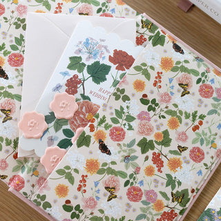 Back interior spread of Reverie planner displaying the lush floral botanical artwork in soft pastels with the convenient back pocket for storing notes and mementos