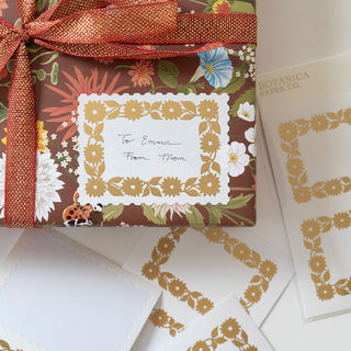 Daisy Decorative Labels, Pack Of 6 illustrated by Oana Befort for Botanica Paper Co. being used on a present.