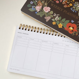 Close-up detail of an opened Wild Flowers Undated Weekly Planner illustrated by Oana Befort for Botanica Paper Co. showing the Weekly Overview page.