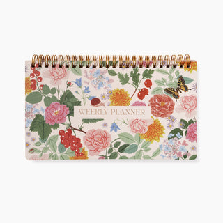 Reverie Undated Weekly Planner illustrated by Oana Befort for Botanica Paper Co. featuring botanical flowers on a light background with a gold foil title.