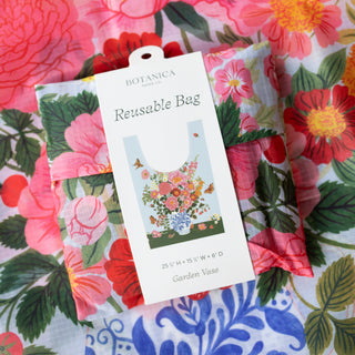 A reusable flower vase bag by Botanica Paper Co. in its packaging, featuring a white paper tag with an illustration of a colorful flower bouquet in a garden vase.