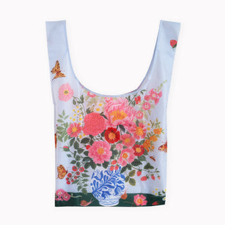 A reusable ripstop bag with a light blue base color, featuring a vibrant floral print of pink, red, and orange flowers, green leaves, butterflies, and a blue-and-white patterned vase near the bottom.