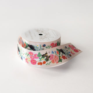Wide printed floral satin ribbon on a spool and white background