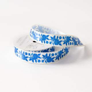 Blue roses printed on a white-cream satin ribbon with a white background