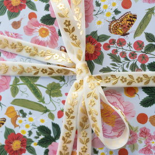 velvet ribbon with gold daisies tied as a bow on a floral gift background