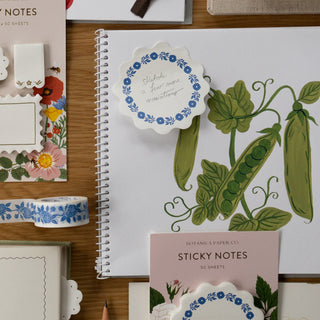 Notebook with decorative sticky notes and stationery items on a wooden surface