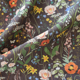 Close-up detail of the Wild Flowers tea towel by Oana Befort showing the natural European linen texture and intricate wildflower illustrations with delicate petals and stems beautifully contrasted against the rich dark background, printed with OEKO-TEX certified non-toxic inks