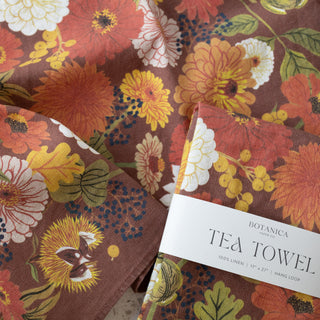 Fall linen tea towel artfully arranged as a seasonal gift, demonstrating how Botanica Paper Co.'s autumn-inspired stationery celebrates the changing seasons and life's cherished moments