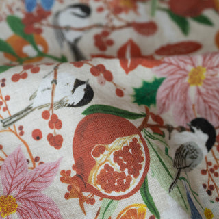 Close-up detail of the Winter tea towel by Oana Befort displaying the fine European linen texture and intricate winter scene with detailed chickadee feathers, pomegranate seeds, and delicate winter botanical elements printed with OEKO-TEX certified non-toxic inks