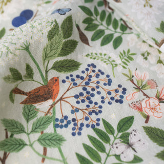 Macro detail of Flowering Trees tea towel by Oana Befort revealing the natural weave of premium European linen fabric with intricate botanical line work and delicate flowering branch illustrations printed in fine detail.