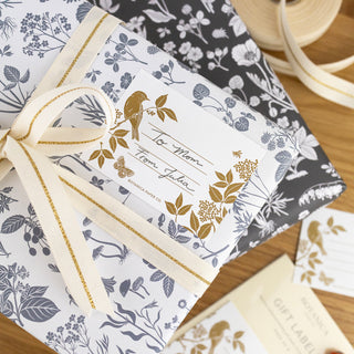 Meadow Gift Labels, Pack Of 8 illustrated by Oana Befort for Botanica Paper Co. being used on a present.