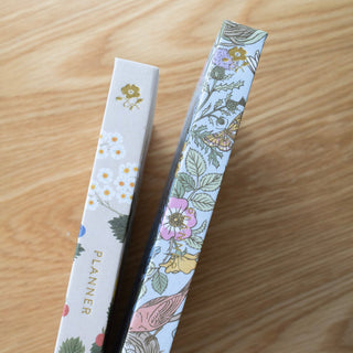 View of the left side of two Linen-Bound planners illustrated by Oana Befort for Botanica Paper Co.