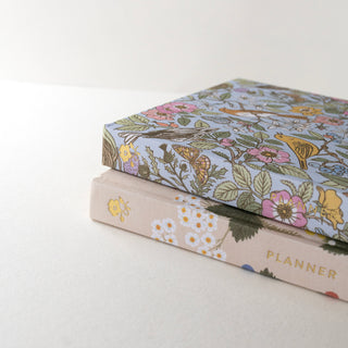 Side view of two Linen Bound Planners illustrated by Oana Befort for Botanica Paper Co.