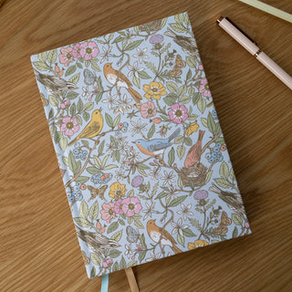 Top view of the Songbirds Linen Bound Planner illustrated by Oana Befort for Botanica Paper Co.