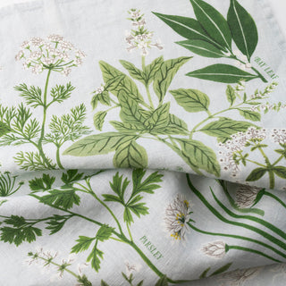 Close-up of the Herb Garden tea towel by Oana Befort revealing the natural linen texture and detailed herb illustrations printed with non-toxic inks, perfect for the kitchen enthusiast who appreciates artful functionality