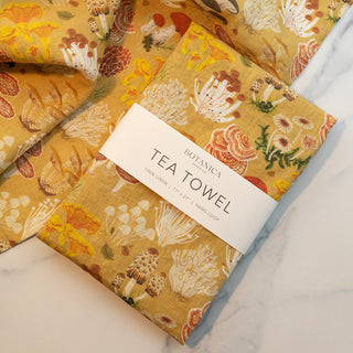 Mushrooms linen tea towel artfully presented as a thoughtful gift, demonstrating how Botanica Paper Co.'s functional art pieces celebrate nature's beauty in life's everyday moments