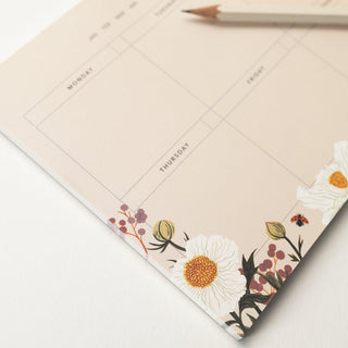 Closeup image of the Poppy Field Weekly Overview Notepad on white background. Art by Oana Befort for Botanica Paper Co.